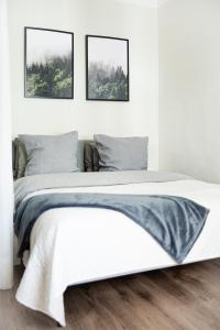 Una cama en un dormitorio con dos cuadros en la pared. en A cosy studio apartment in the heart of Tallinn, en Tallin