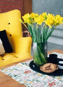 un vaso di fiori gialli seduto su un tavolo di Wolfpack Guest House a Białka