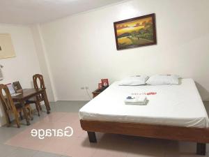 a bedroom with a bed and a table with a table at OYO 1026 Evita Hotel Bacoor in Cavite