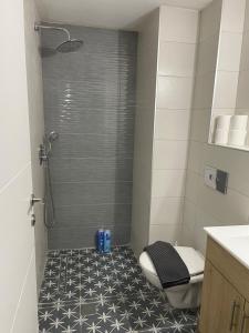 a bathroom with a shower with a black and white floor at Lovely flat in Tel Aviv 32 in Tel Aviv