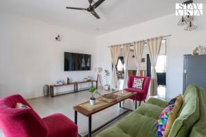a living room with two chairs and a table at StayVista at Mangifera Agro Estate with Pool, Wi-Fi in Pune