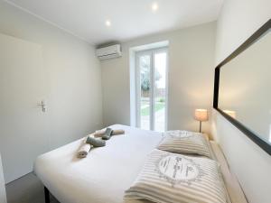 een witte slaapkamer met een bed en een raam bij Superdominante in Beausoleil