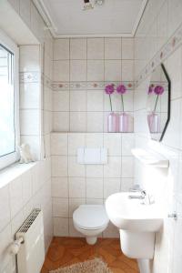 a white bathroom with a toilet and a sink at Schönes Zimmer am Jans Kamp 3 mit Küche Self-Check-In in Vechta