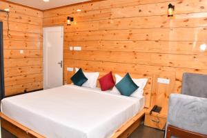 1 dormitorio con 1 cama en una pared de madera en Hotel The Crown, Dharamshala, en Dharamshala