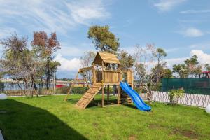 a wooden playground with a slide in a yard at Luxury Villa Salt & Stone with spa area in Nin in Nin