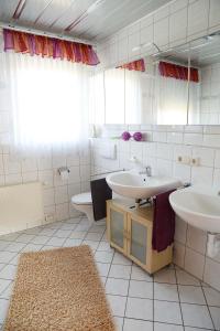 a white bathroom with two sinks and a toilet at Schönes Zimmer am Jans Kamp 3 mit Küche Self-Check-In in Vechta