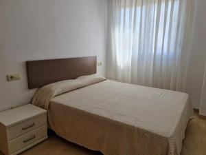 - une chambre avec un lit, une commode et une fenêtre dans l'établissement Apartamentos-Atico Reformados Pompeya I y II, à Peñíscola