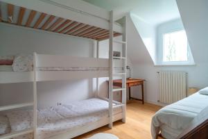 a bedroom with two bunk beds and a desk at Kerfeunteun - Grande maison à 15min de la plage in Quimperlé