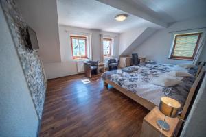 a bedroom with a large bed and wooden floors at Wellness Penzion Life in Číměř +90 photos