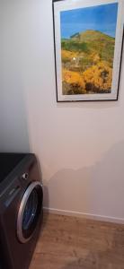 - un lave-linge dans une pièce avec une photo sur le mur dans l'établissement Gite 2 Le Loft du ChAtÔ, à Quend