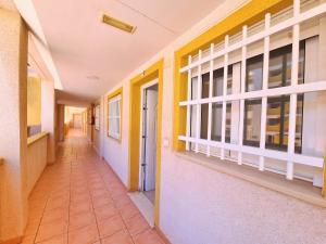 a hallway of a school with yellow and white walls at Mar de Cristal Resort Apartamentos - Parking in Mar de Cristal