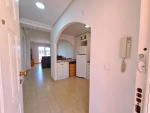 a kitchen with an archway and a white refrigerator at Mar de Cristal Resort Apartamentos - Parking in Mar de Cristal