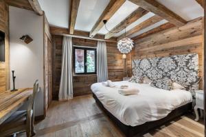 ein Schlafzimmer mit einem großen Bett in einem Zimmer mit Holzwänden in der Unterkunft Residence Savoie - 4 Pièces pour 8 Personnes 664 in Val dʼIsère
