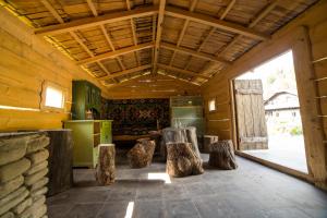 Zimmer mit Holzwänden und einer Küche mit Holzscheiten in der Unterkunft Casa Poveste Pensiunea-Muzeu in Câmpulung Moldovenesc