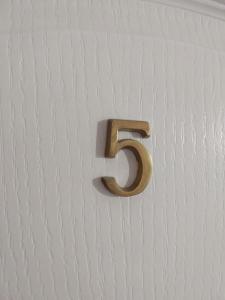 a gold number on a white wall at Willa Jack in Władysławowo