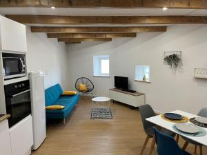 a living room with a blue couch and a table at Maison charmante pour 4/6 pers in Brassac-les-Mines