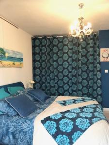 1 dormitorio con cama y lámpara de araña en chambre océan en Pleurtuit