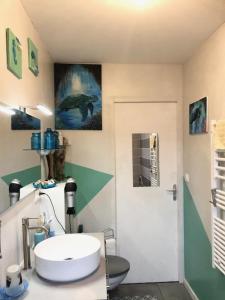 La salle de bains est pourvue d'un lavabo et de toilettes. dans l'établissement chambre océan, à Pleurtuit
