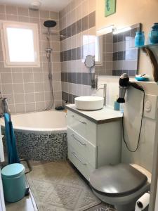 La salle de bains est pourvue de toilettes, d'un lavabo et d'une baignoire. dans l'établissement chambre océan, à Pleurtuit