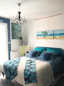 a bedroom with a bed and a chandelier at chambre océan in Pleurtuit