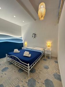 a bedroom with a large bed with a blue blanket at Le Case del Marinaio in San Vito lo Capo