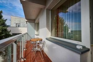 einen Balkon mit einem Stuhl und einem Fenster in der Unterkunft Hotel SOREA REGIA in Bratislava