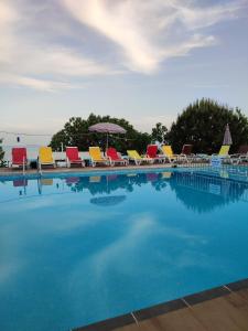 a large swimming pool with chairs and an umbrella at Makara camp in Şarköy