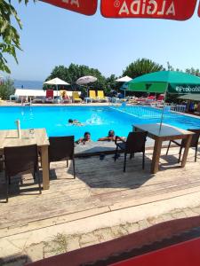 una piscina con mesa y sillas y gente en el agua en Makara camp en Şarköy