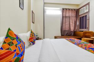 um quarto com uma cama branca e um sofá em FabHotel Moon Light Palace em Jaipur