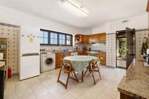 a kitchen with a table and a refrigerator at Alto da Praia Villa in Colares