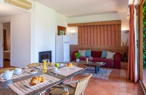 a living room with a table and chairs and a couch at Pedras D'el Rei in Tavira