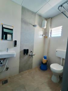 een badkamer met een douche, een toilet en een wastafel bij Hotel Heritage Palace in Bhuj