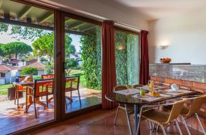 a dining room with sliding glass doors and a table and chairs at Pedras D'el Rei in Tavira