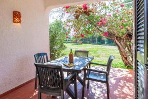 a table and chairs on a patio with a tree at Pedras D'el Rei in Tavira