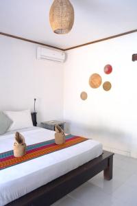 a bedroom with a bed with two baskets on it at Rumah DOLE in Gili Islands