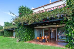 a building with a table and chairs in a yard at Pedras D'el Rei in Tavira