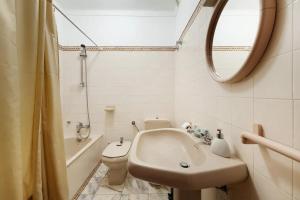 a bathroom with a sink and a toilet and a mirror at Alto da Praia Villa in Colares