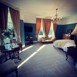 a bedroom with blue walls and a bed and a chandelier at Ashleigh Buxton in Buxton