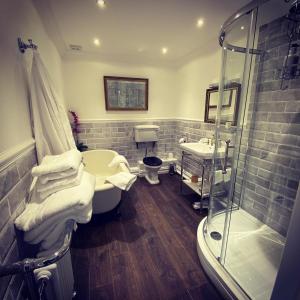 uma casa de banho com um chuveiro, uma banheira e um lavatório. em Ashleigh Buxton em Buxton