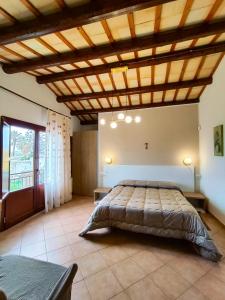 a bedroom with a large bed with a wooden ceiling at Casolare Nelle Saline in Torre Nubia