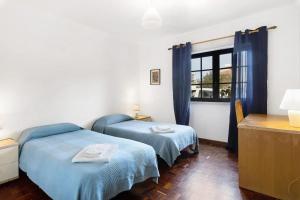 a bedroom with two beds and a window at Alto da Praia Villa in Colares