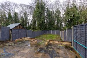 an empty backyard with a fence and a yard at 3BR Home with Driveway Leamington Spa Town Centre in Leamington Spa