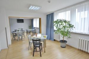 uma sala com mesas e cadeiras e um vaso de plantas em Twój Hostel Bytom em Bytom
