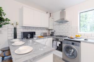 a kitchen with a table with plates and wine glasses at 3BR Home with Driveway Leamington Spa Town Centre in Leamington Spa
