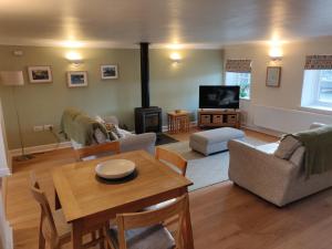 a living room with a table and a tv at Weavers Cottage in Haverfordwest