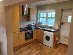 een keuken met een wasmachine en een wasmachine bij Weavers Cottage in Haverfordwest
