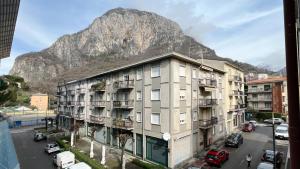 uma vista para um edifício com uma montanha ao fundo em La casa di Ange - Affitti Brevi Italia em Lecco