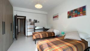 um quarto com 2 camas e uma secretária. em La casa di Ange - Affitti Brevi Italia em Lecco