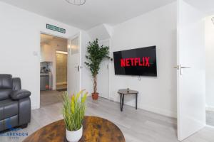 a living room with anetflix sign on the wall at 3BR Home with Driveway Leamington Spa Town Centre in Leamington Spa