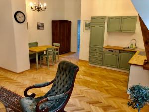 eine Küche mit grünen Schränken und einem Stuhl in einem Zimmer in der Unterkunft Herrnhof Appartement Adele in Neunkirchen